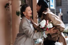a woman in brown coat greeting her grandmother